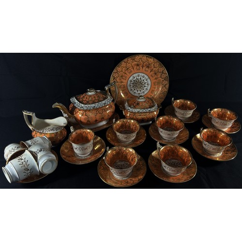 56 - An early 19th century tea service in salmon and gilt comprising teapot and stand, cups and saucers, ... 