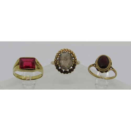 233 - Three vintage gem set gold rings; a 10k scissor-cut synthetic ruby example, size R, and two 9ct exam... 