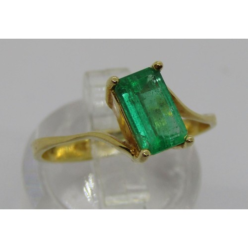 238 - 18k emerald-cut emerald crossover ring, the stone 8 x 5mm approx, size O, 2.5g