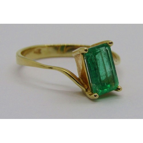 238 - 18k emerald-cut emerald crossover ring, the stone 8 x 5mm approx, size O, 2.5g