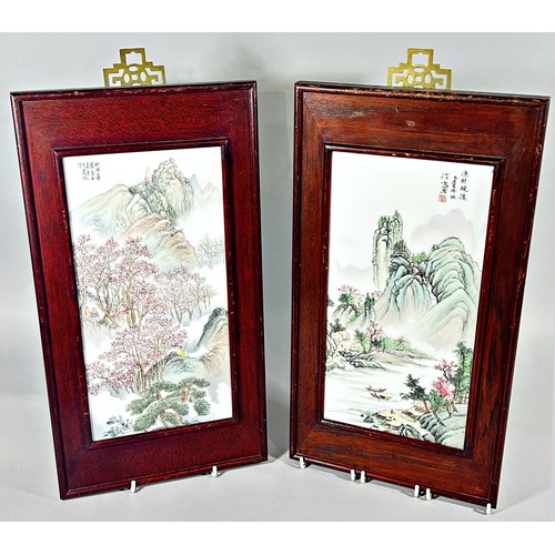 103 - A pair of 20th century Chinese porcelain wall plaques, painted with landscape scenes, with script/in... 