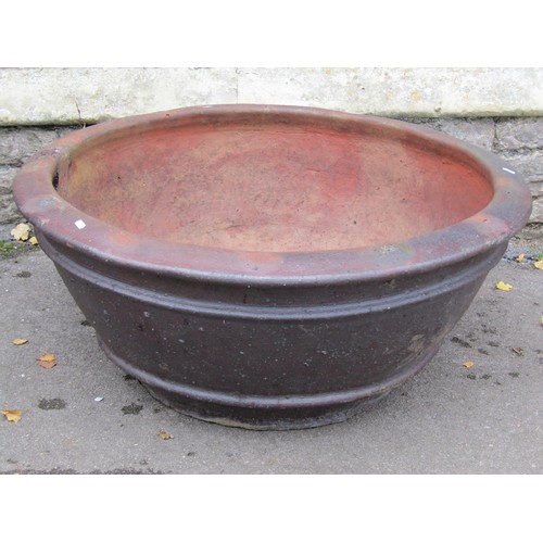 1032 - A large matt glazed terracotta planter of circular tapered ribbed for 44cm high x 100cm diameter, to... 