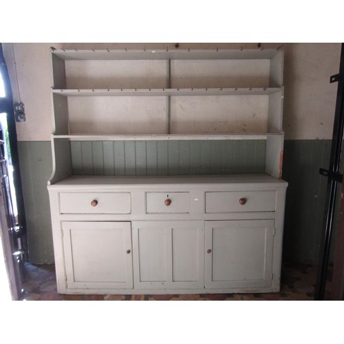 1072 - A painted pine farmhouse kitchen dresser, the base enclosed by three panelled doors and three frieze... 