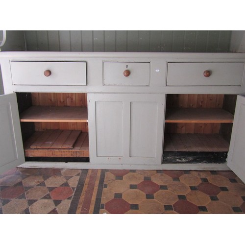 1072 - A painted pine farmhouse kitchen dresser, the base enclosed by three panelled doors and three frieze... 