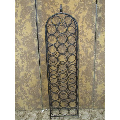 1073 - An iron work floor standing wine bottle rack with circular divisions to hold 32 bottles, 140cm (full... 