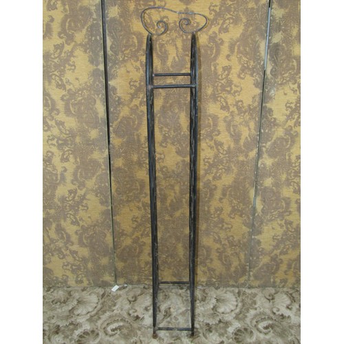 1073 - An iron work floor standing wine bottle rack with circular divisions to hold 32 bottles, 140cm (full... 