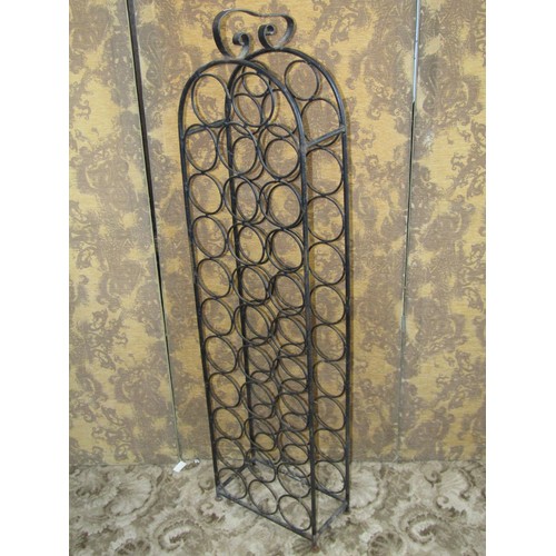 1073 - An iron work floor standing wine bottle rack with circular divisions to hold 32 bottles, 140cm (full... 