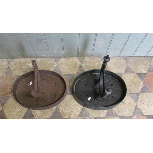 1058 - A pair of cast iron Victorian boot scrapers raised/set in oval tray bases, (af one painted, the othe... 