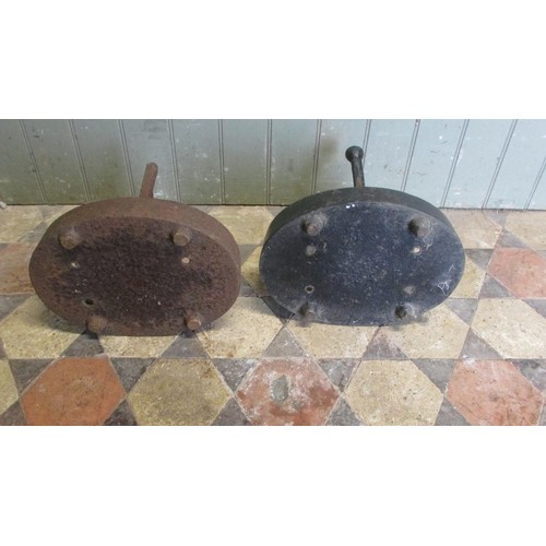 1058 - A pair of cast iron Victorian boot scrapers raised/set in oval tray bases, (af one painted, the othe... 