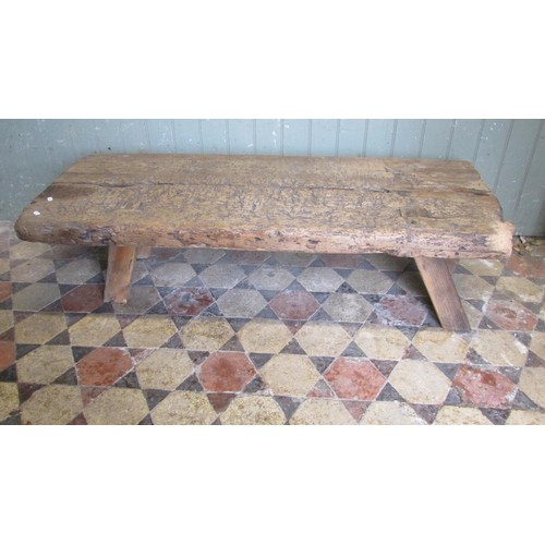 1057 - An antique pine pig bench with through jointed splayed legs, 36cm high x 138cm long x 56cm wide