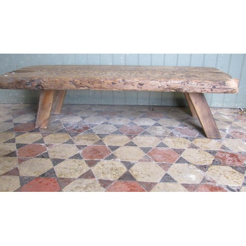 1057 - An antique pine pig bench with through jointed splayed legs, 36cm high x 138cm long x 56cm wide