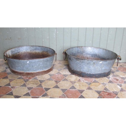 1060 - Two similar vintage weathered oval zinc and cast iron bath planters with loose drop ring handles, 25... 