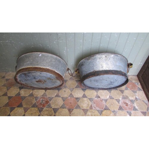 1060 - Two similar vintage weathered oval zinc and cast iron bath planters with loose drop ring handles, 25... 