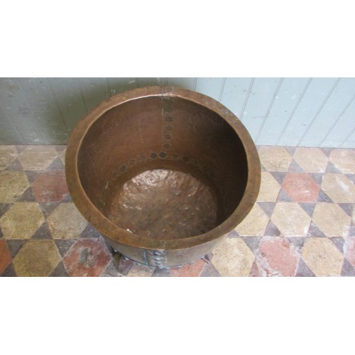 1052 - An antique copper cauldron with flared rim and pop rivetted banded seams, raised on a later bespoke ... 