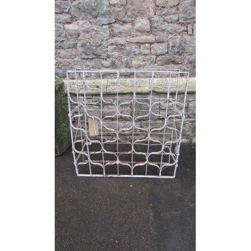 1044 - A vintage painted iron wine rack with bound whiplash divisions, 75cm high x 72cm wide x 30cm deep