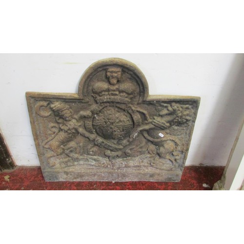 1078 - An old English style cast iron fireback of stepped arched form, with raised armorial shield, flanked... 