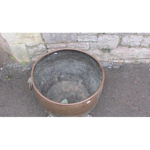 1064 - An antique copper cauldron/log bin with pop rivetted seams, lions mask and ring handles and paw feet... 