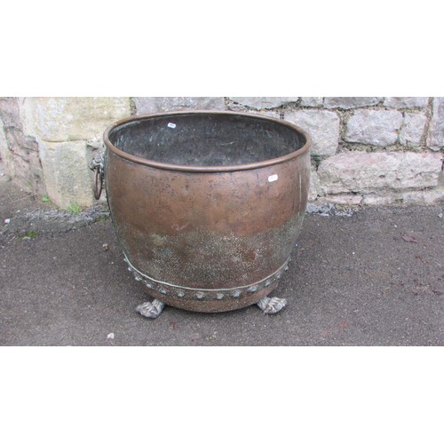 1064 - An antique copper cauldron/log bin with pop rivetted seams, lions mask and ring handles and paw feet... 