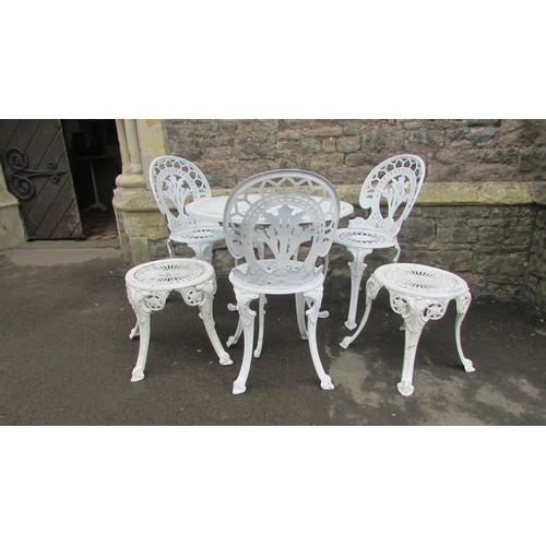 1009 - A cream painted cast aluminium garden terrace table of circular form with decorative pierced radiati... 