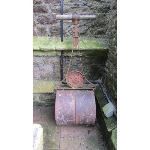 1022 - A small vintage cast iron garden roller together with a pair of painted cast iron garden bench ends ... 