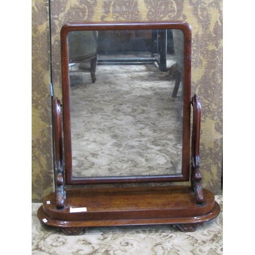 1132 - A Victorian mahogany toilet mirror with scrolled supports set on an oval platform base, approx 80 cm... 