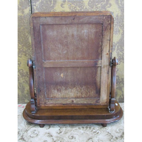 1132 - A Victorian mahogany toilet mirror with scrolled supports set on an oval platform base, approx 80 cm... 