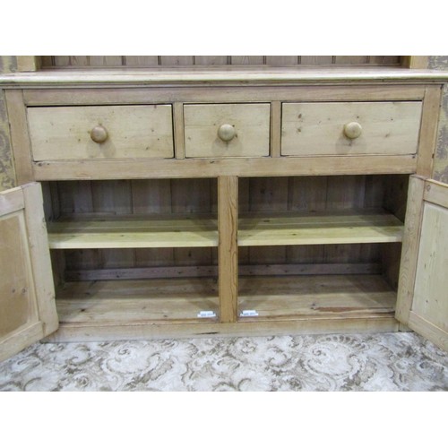 1147 - A stripped pine farmhouse kitchen dresser the base enclosed by a pair of panelled doors and three fr... 