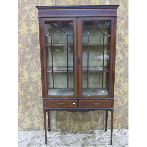 1149 - An inlaid Edwardian mahogany display cabinet partially enclosed by a pair of glazed panelled doors, ... 