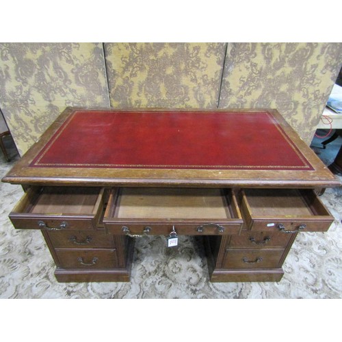 1156 - An oak pedestal desk in the Georgian style with inset leather panelled top over nine frieze drawers,... 