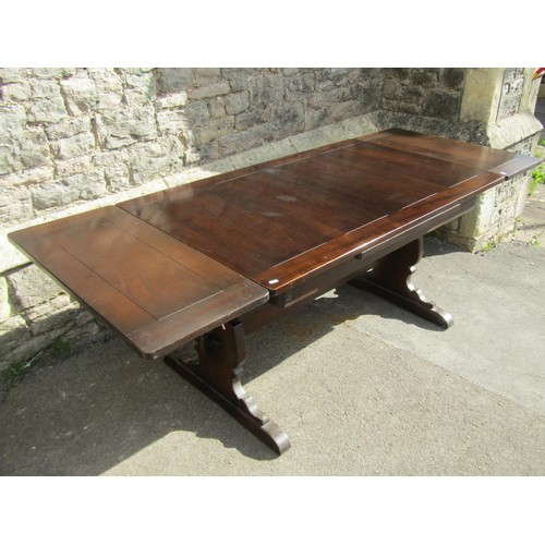 1167 - A dark stained refectory table raised on shaped supports and sledge feet united by a pegged rails, (... 