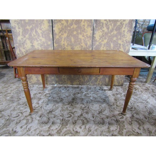 1168 - A pine rectangular kitchen table with central frieze drawer raised on turned supports, 74cm high x 1... 