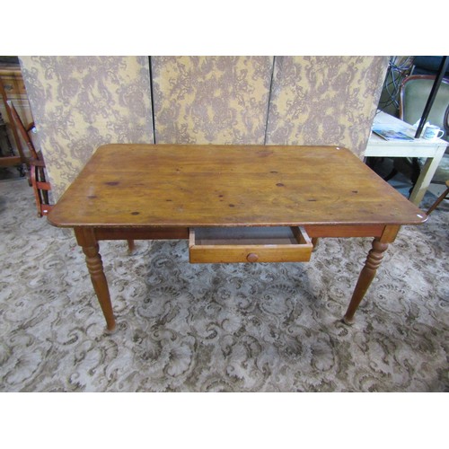 1168 - A pine rectangular kitchen table with central frieze drawer raised on turned supports, 74cm high x 1... 