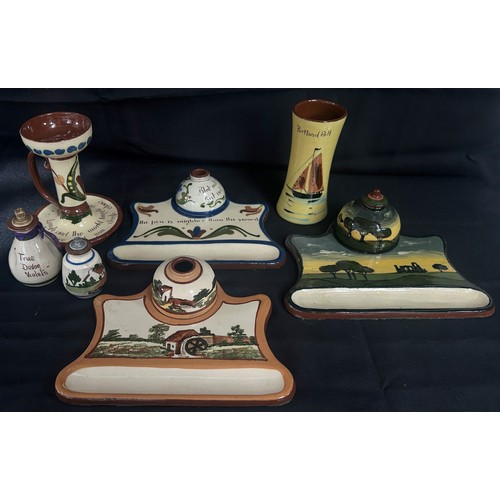 130 - A group of Torquay motto wares, to include chamber stick, inkwells etc