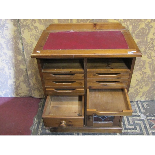 1179 - A contemporary stained pine side cabinet or counter with inset faux leather panel top over an arrang... 