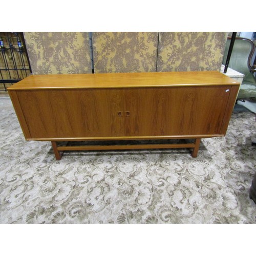 1181 - A retro teak sideboard enclosed by a pair of sliding doors, with loose paper label to interior, The ... 