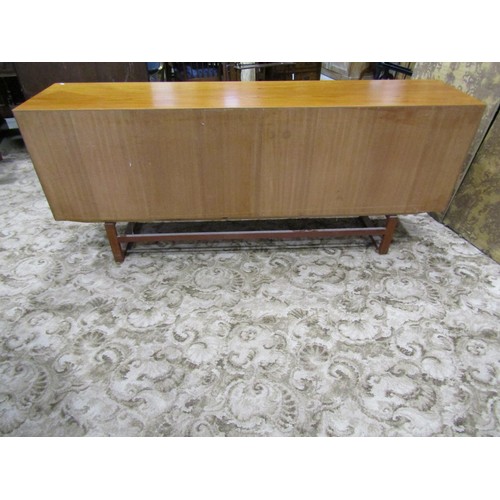 1181 - A retro teak sideboard enclosed by a pair of sliding doors, with loose paper label to interior, The ... 