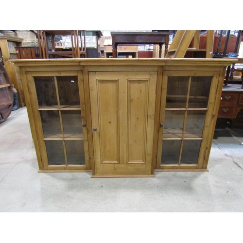 1185 - A 19th century stripped and waxed pine breakfront cabinet, the central door flanked by two glazed pa... 