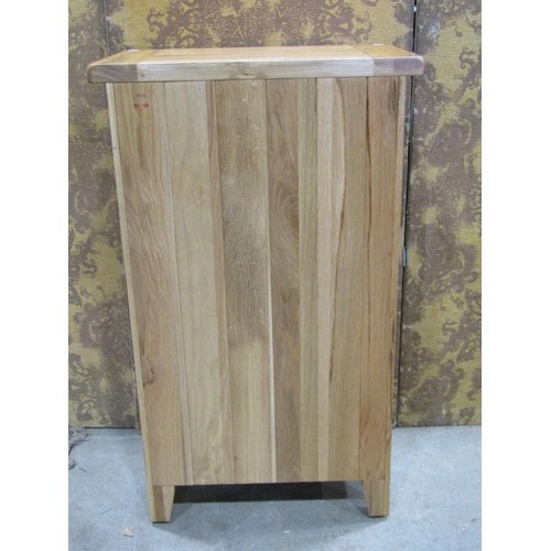 1194 - A contemporary oak free standing side cupboard partially enclosed by a panelled door beneath a friez... 