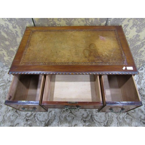 1203 - An Edwardian Georgian style kneehole writing table with inset leather top, over three frieze drawers... 