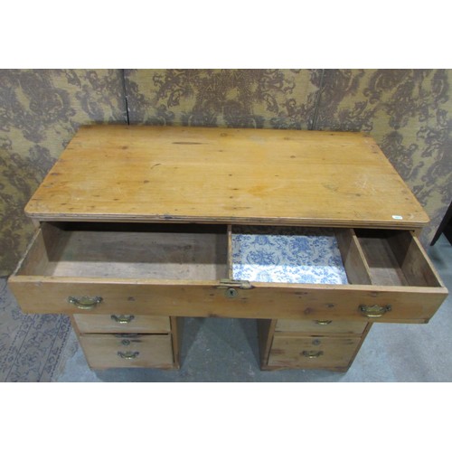 1229 - A 19th century stripped pine kneehole twin pedestal desk fitted with an arrangement of seven drawers... 