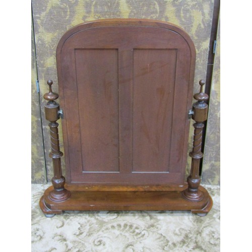 1236 - A Victorian mahogany toilet mirror with moulded arched frame raised on turned column supports and sh... 