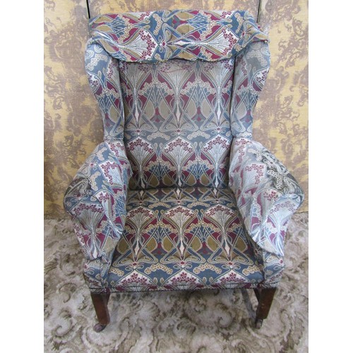 1251 - A Georgian style wing chair with shaped outline and stylised floral upholstery raised on square cut ... 