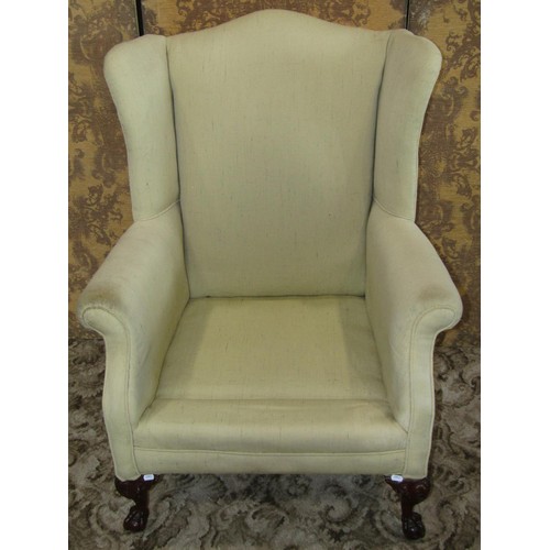 1253 - A reproduction Georgian style wing armchair raised on claw and ball supports