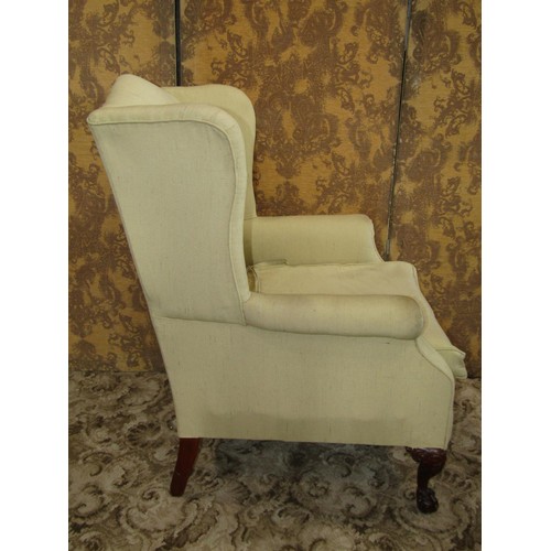 1253 - A reproduction Georgian style wing armchair raised on claw and ball supports