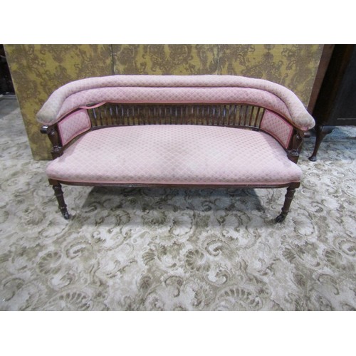 1258 - An Edwardian low backed parlour/bedroom sofa with repeating light pink ground upholstered seat, back... 