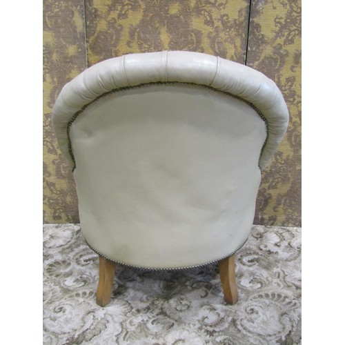 1265 - A Victorian style drawing room chair and matching footstool with buttoned cream leather upholstery