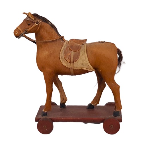 645 - Small antique toy horse, well modelled in wood and covered in pony skin, with leather bridle and sad... 