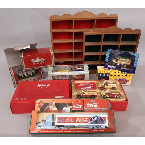 668 - A mixed collection of boxed toys cars together with 4 wooden display units. Models include 33 Coca C... 