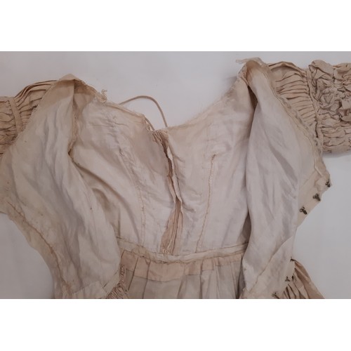 679 - Three late 19th /early 20th century garments comprising the following; a dress in ivory jacquard sil... 