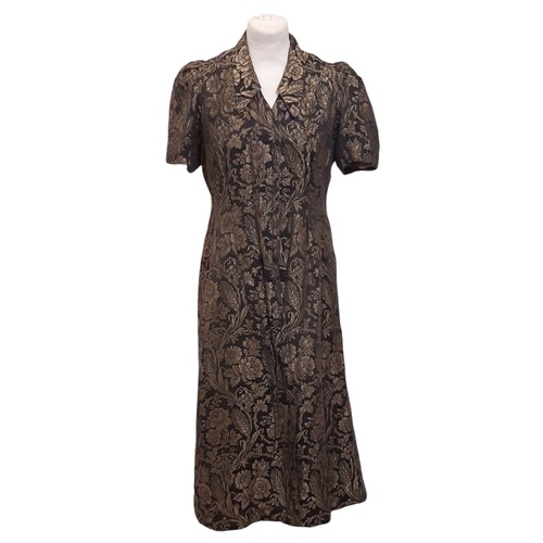 682 - 1930's short sleeved tailored jacket in black and gold fabric with a woven floral pattern and hook a... 